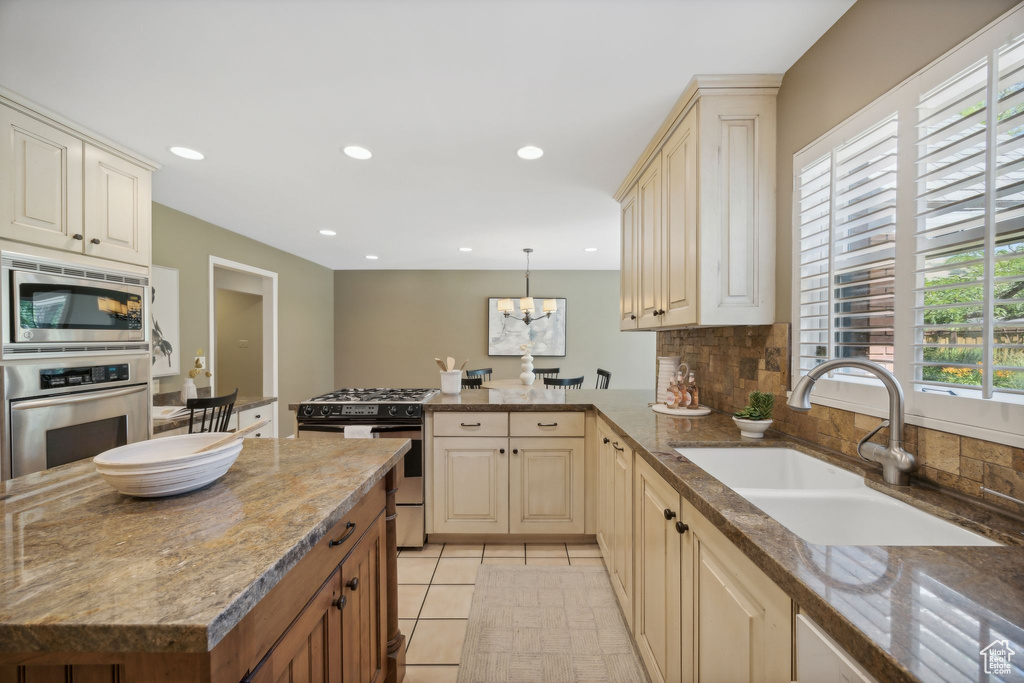 Kitchen with backsplash, a wealth of natural light, appliances with stainless steel finishes, and sink