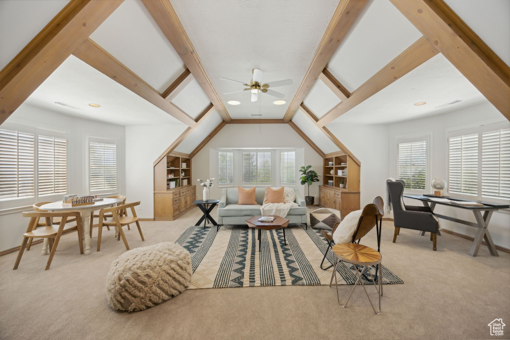 Carpeted living room with lofted ceiling with beams and ceiling fan