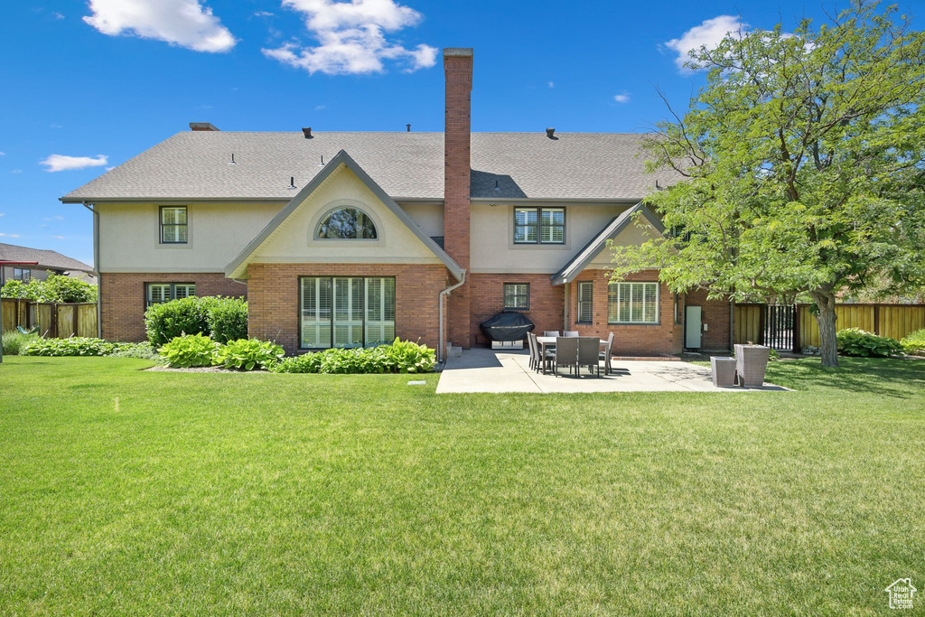 Back of house featuring a patio and a lawn