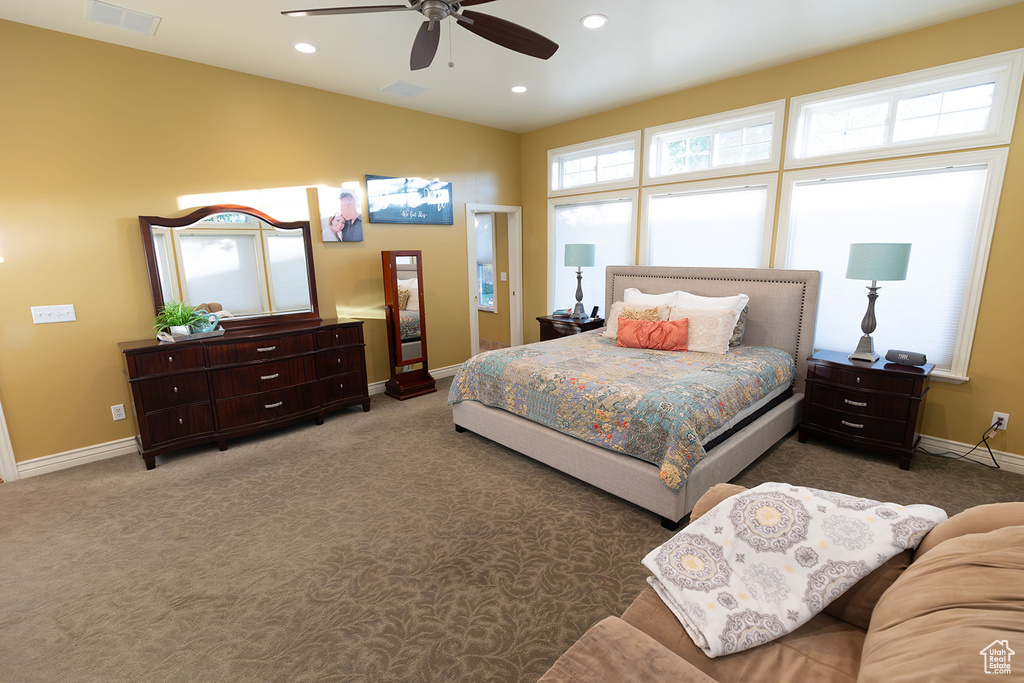 Bedroom with dark colored carpet and ceiling fan