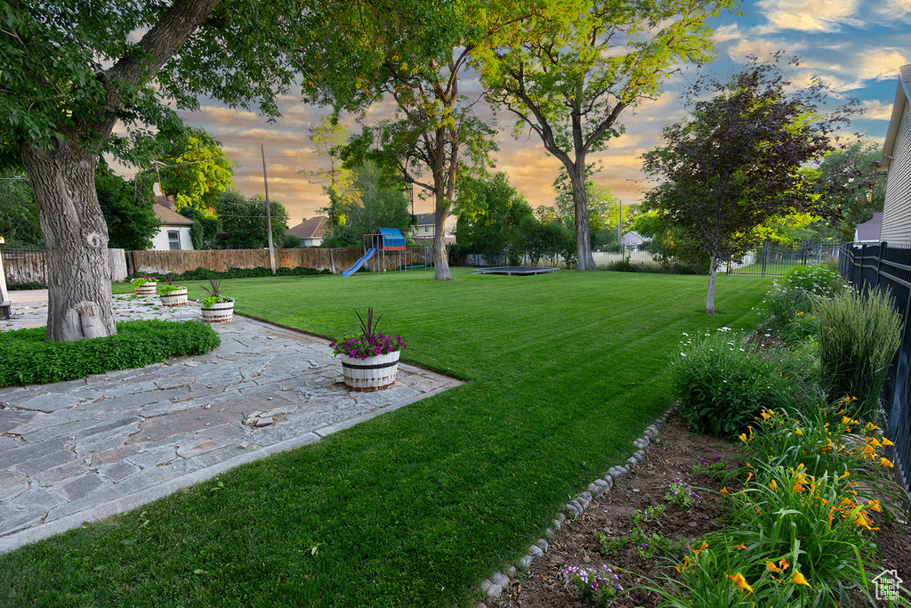 Yard at dusk featuring a playground