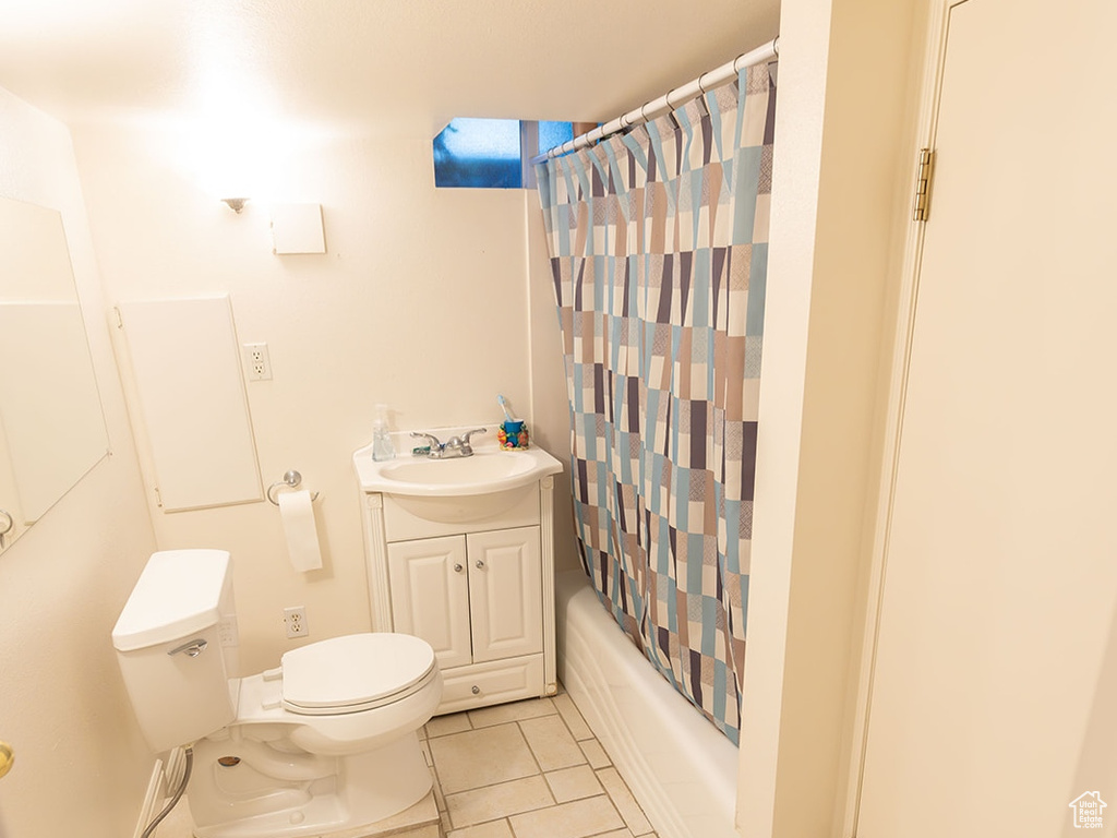 Full bathroom with vanity, shower / tub combo with curtain, toilet, and tile patterned floors