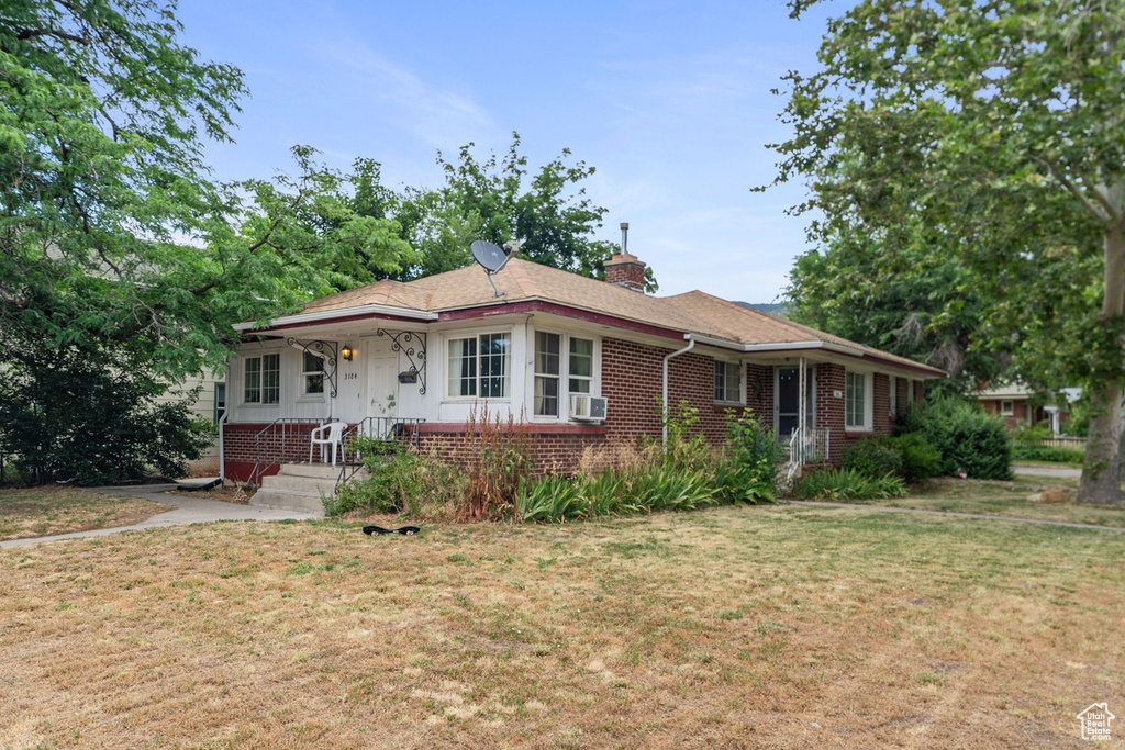 Single story home featuring cooling unit and a front lawn