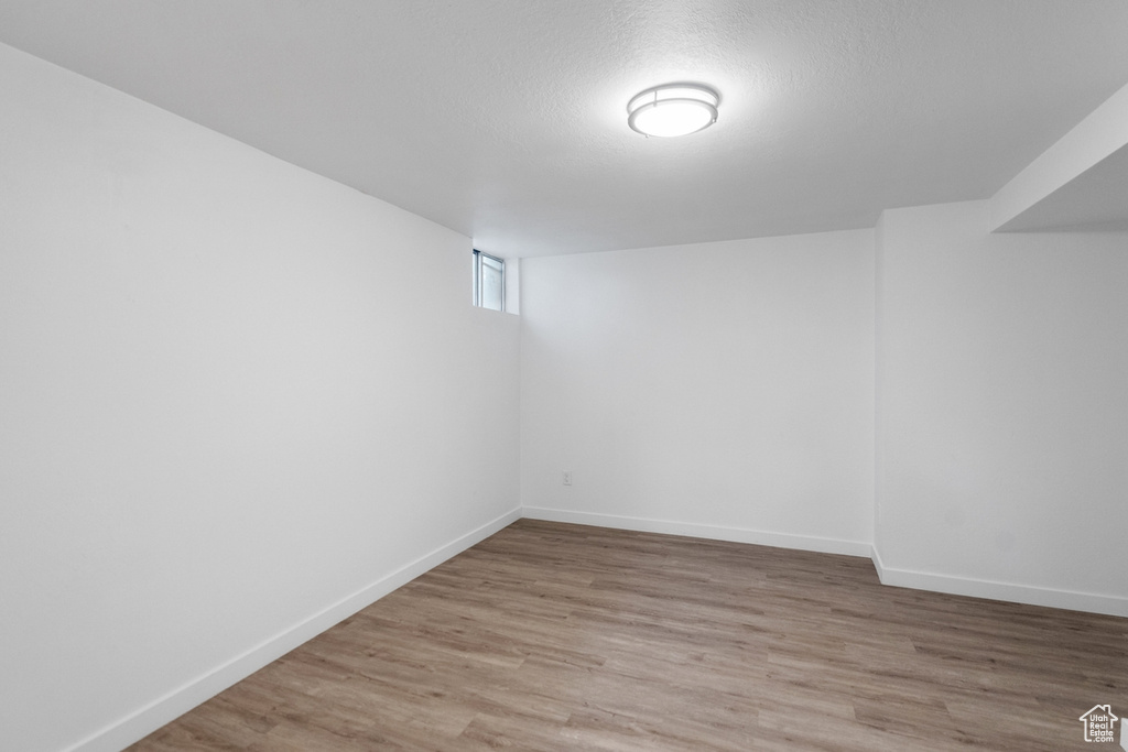 Basement featuring a textured ceiling and wood-type flooring