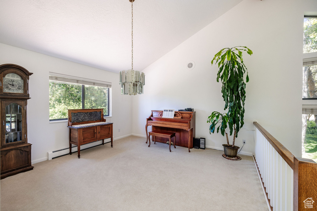 Sitting room featuring high vaulted ceiling, carpet, baseboard heating, and a notable chandelier