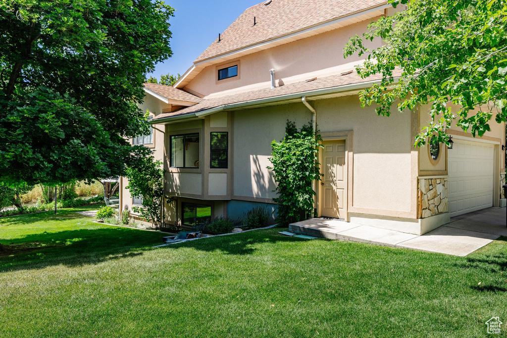 Back of property featuring a garage and a yard