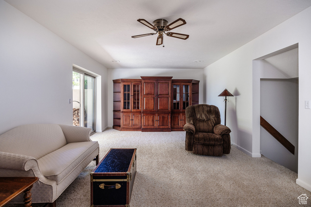 Carpeted living room with ceiling fan