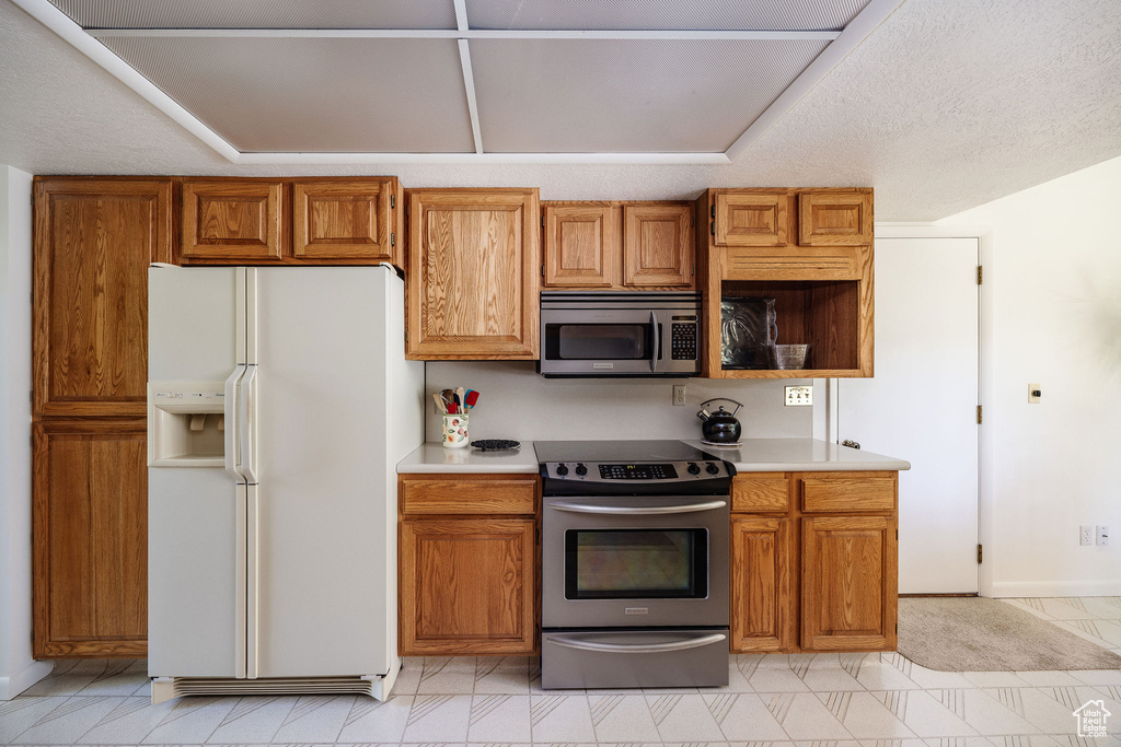 Kitchen with appliances with stainless steel finishes and light tile patterned floors