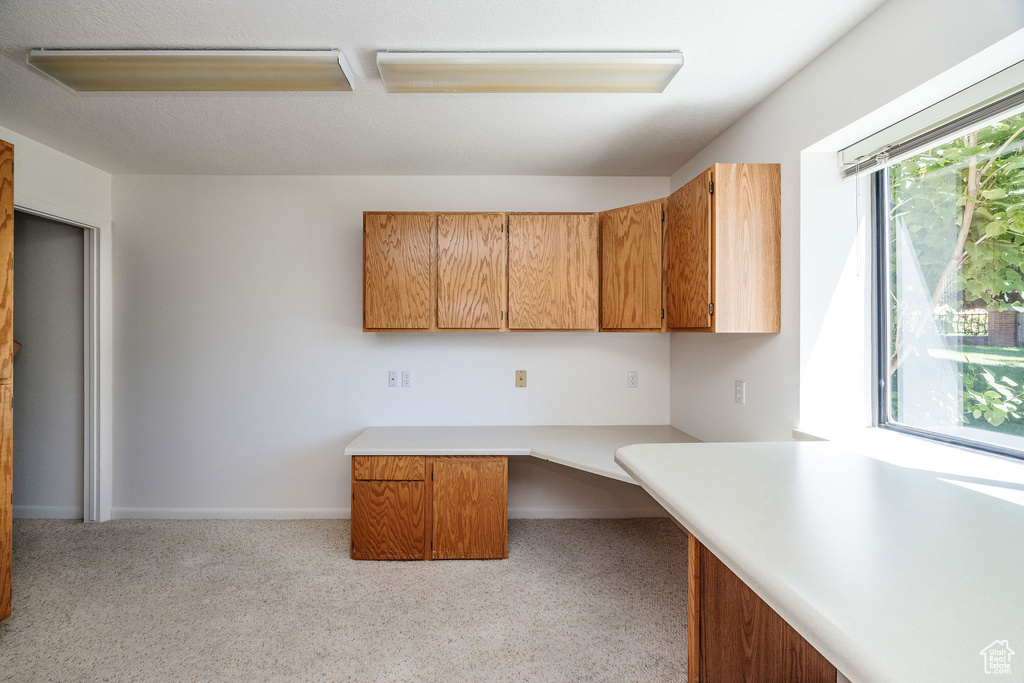 Interior space with light carpet and built in desk