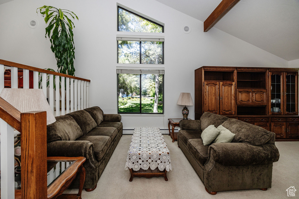 Carpeted living room featuring a baseboard heating unit, beamed ceiling, and high vaulted ceiling