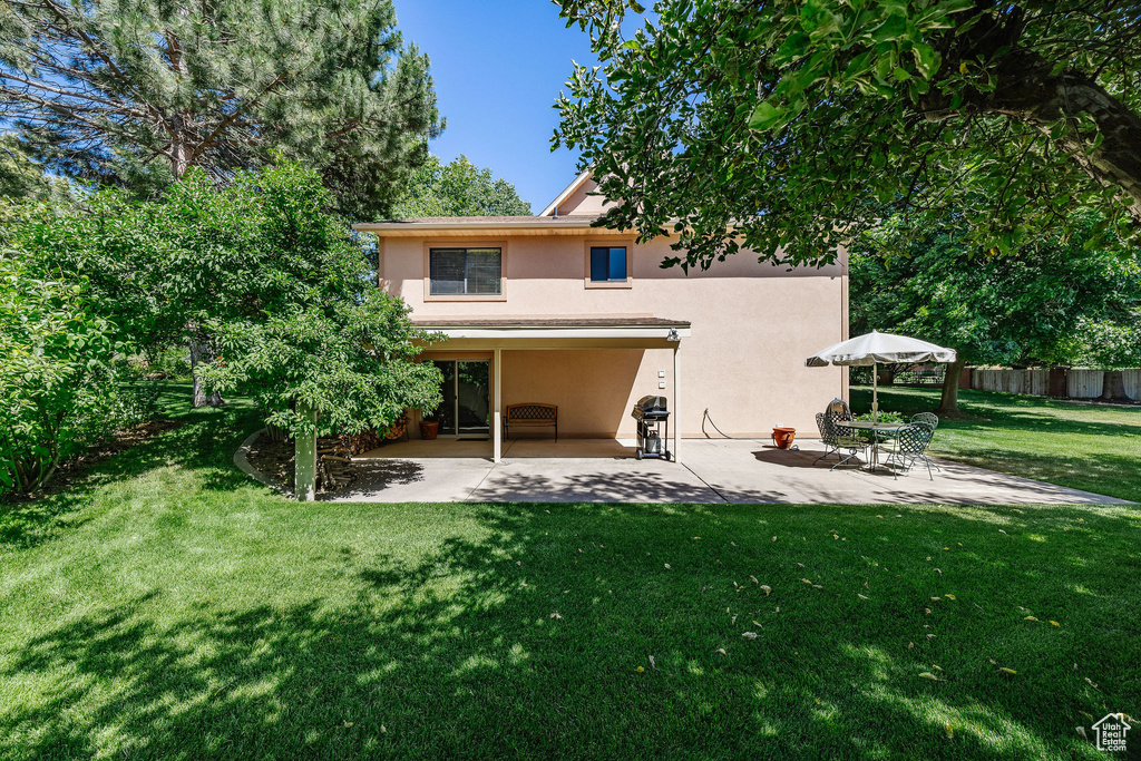 Rear view of property with a patio area and a yard