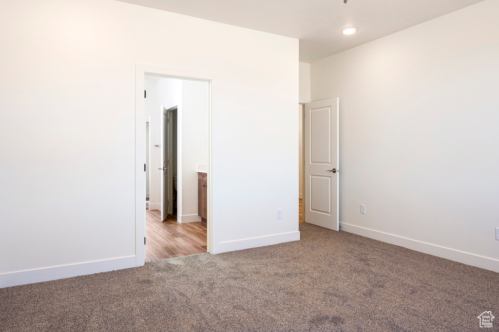 Unfurnished bedroom with light colored carpet