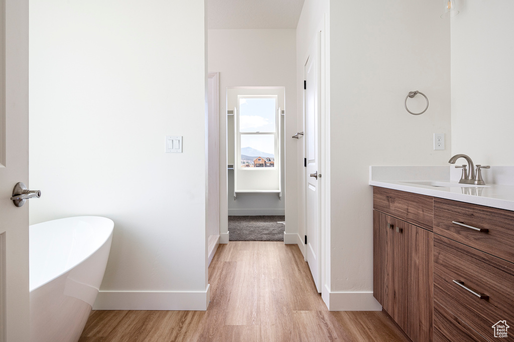 Bathroom featuring vanity, hardwood / wood-style flooring, and a bathtub