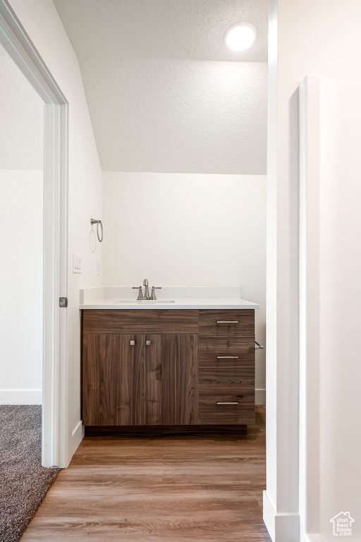 Bathroom featuring wood-type flooring, a textured ceiling, and vanity