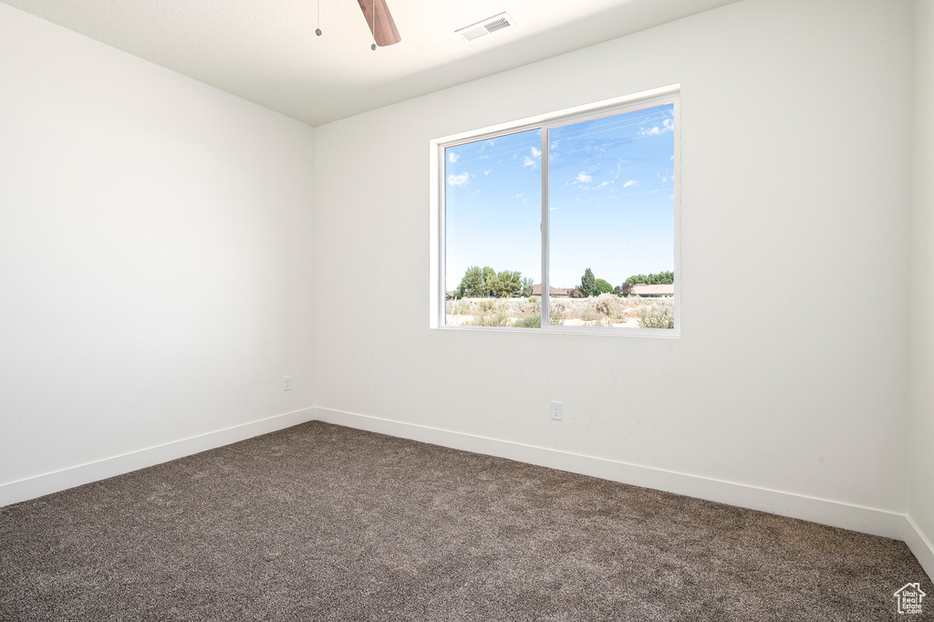 Carpeted spare room featuring ceiling fan