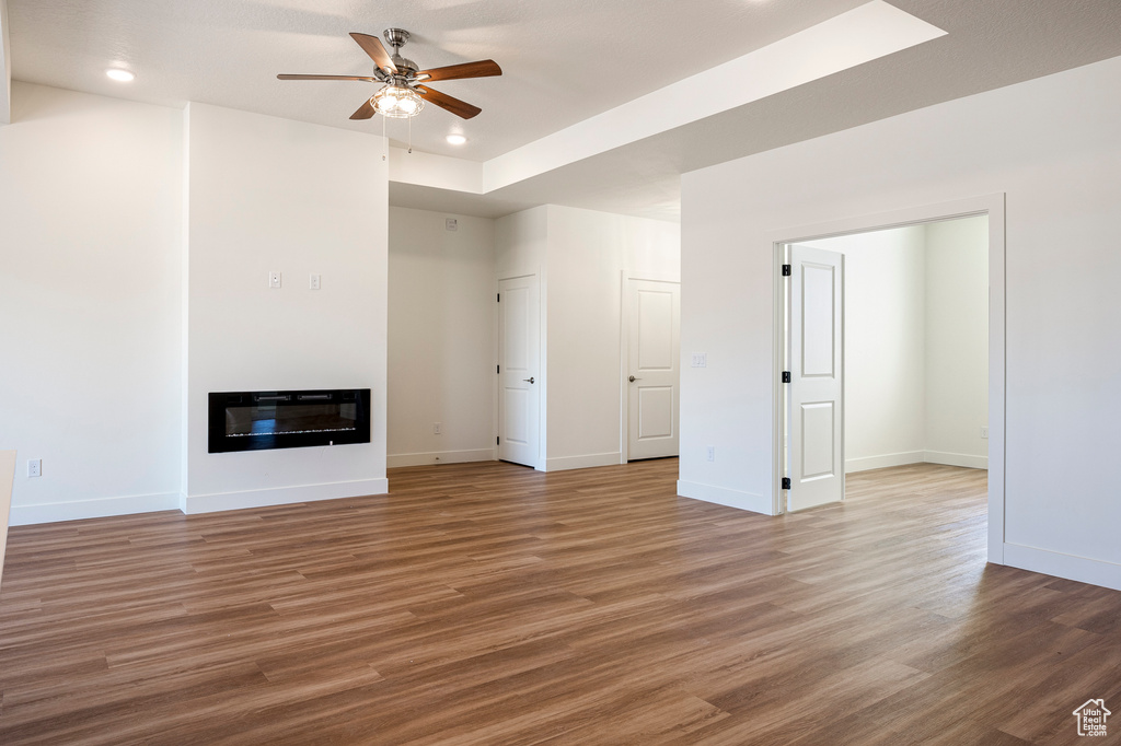 Unfurnished living room with ceiling fan and light wood-type flooring