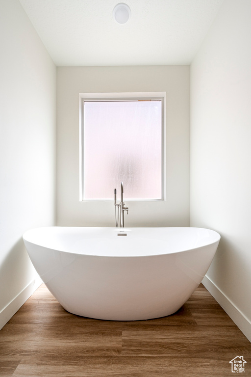 Bathroom featuring a washtub and hardwood / wood-style flooring