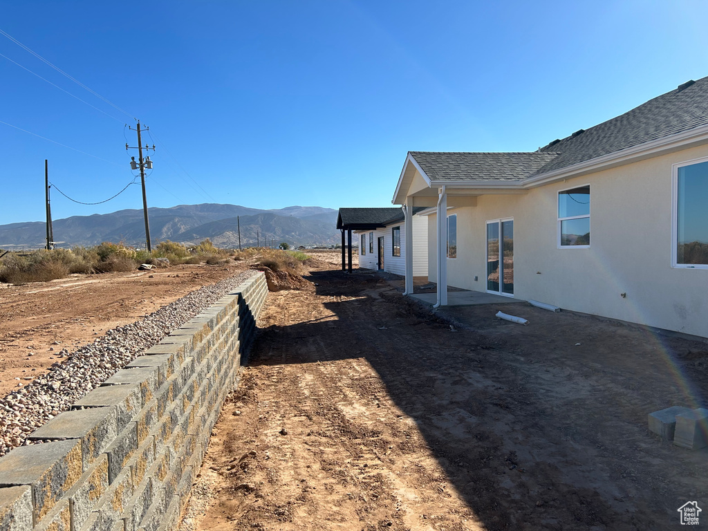 View of side of property with a mountain view and a patio area