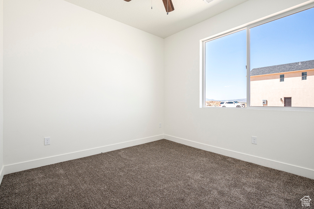 Carpeted empty room featuring ceiling fan