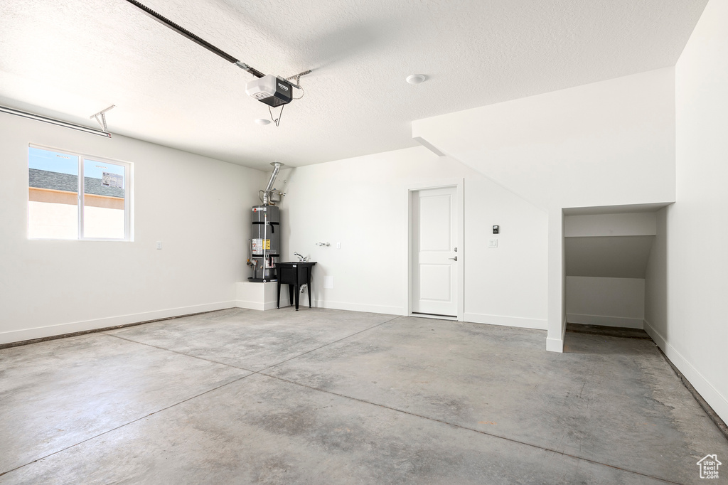 Garage featuring water heater and a garage door opener