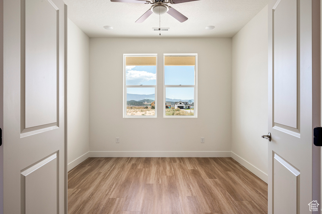 Unfurnished room featuring ceiling fan and light hardwood / wood-style flooring