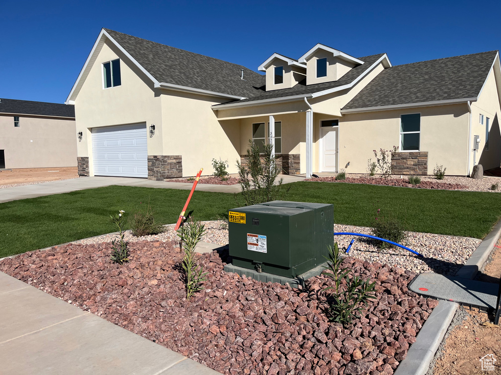 View of front of house with a garage and a front yard