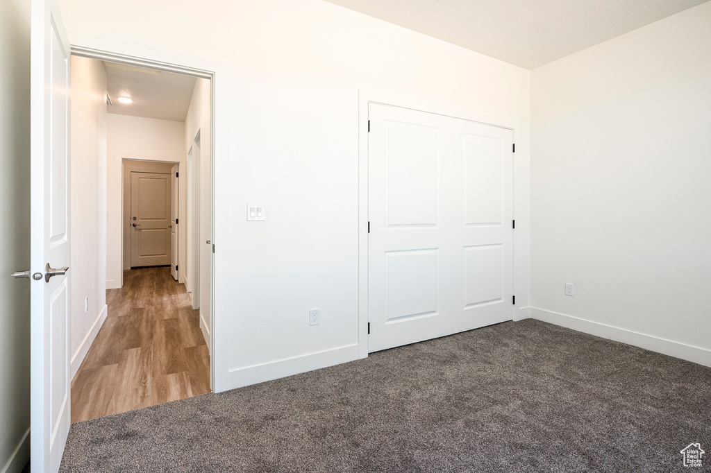 Unfurnished bedroom featuring light carpet and a closet