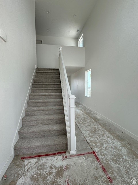 Stairs featuring a wealth of natural light and a high ceiling