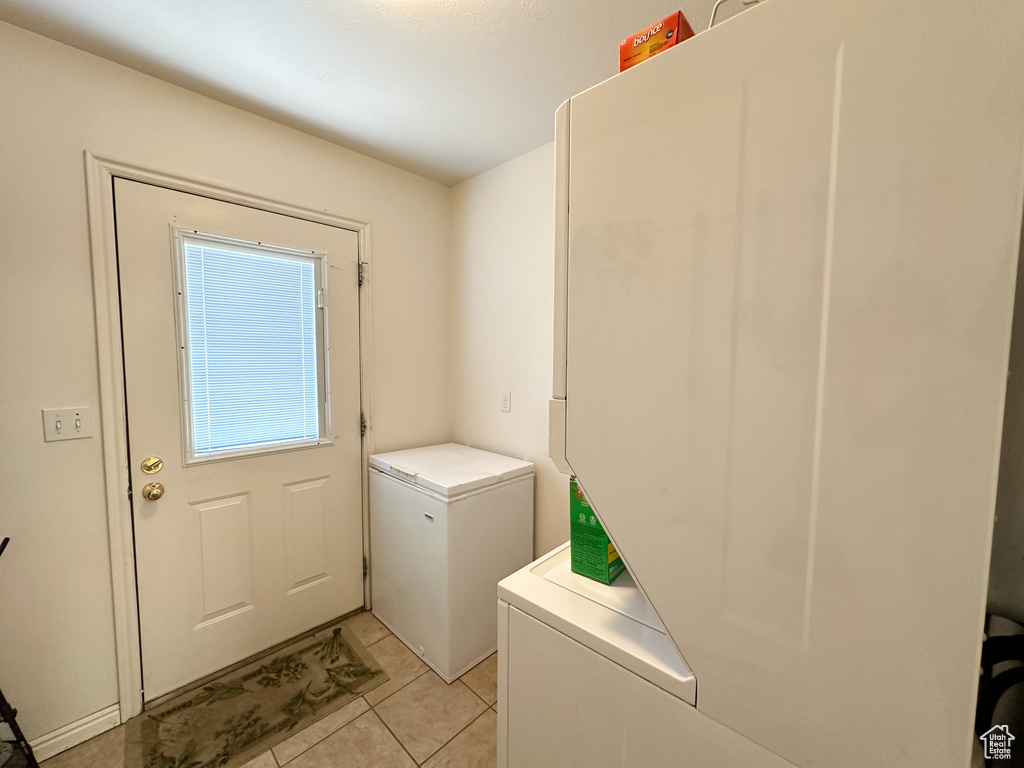 Laundry area with light tile patterned floors