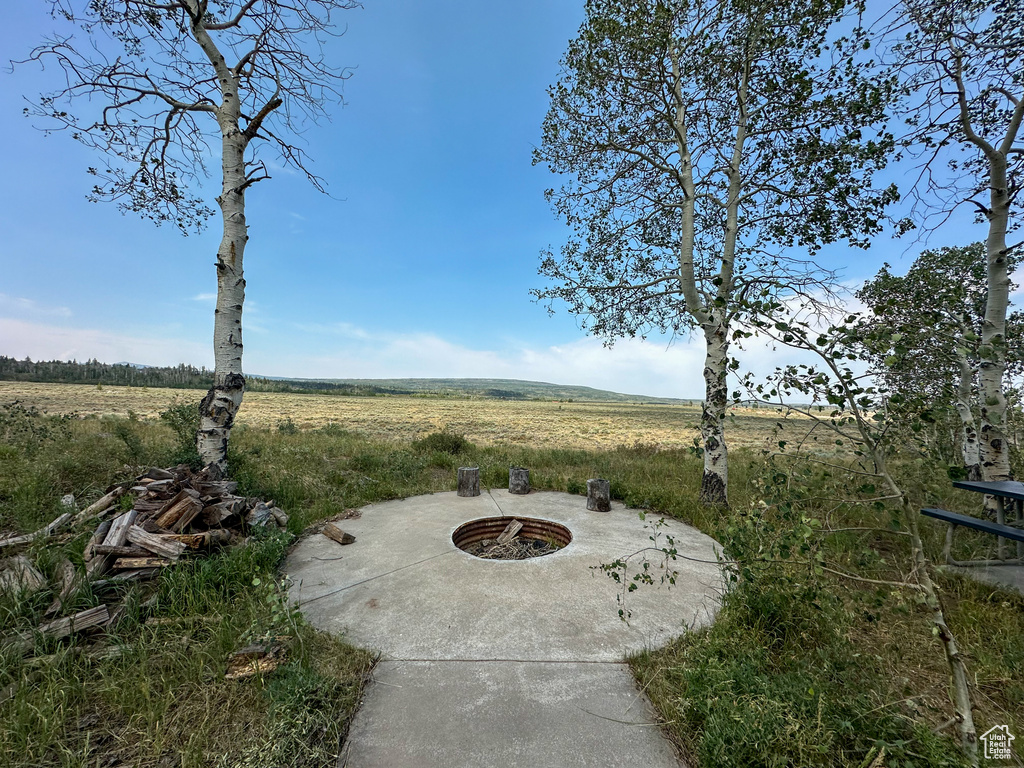 View of patio with a rural view and a fire pit