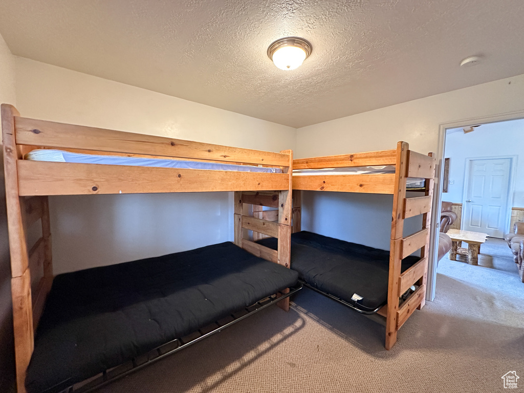 Carpeted bedroom featuring a textured ceiling