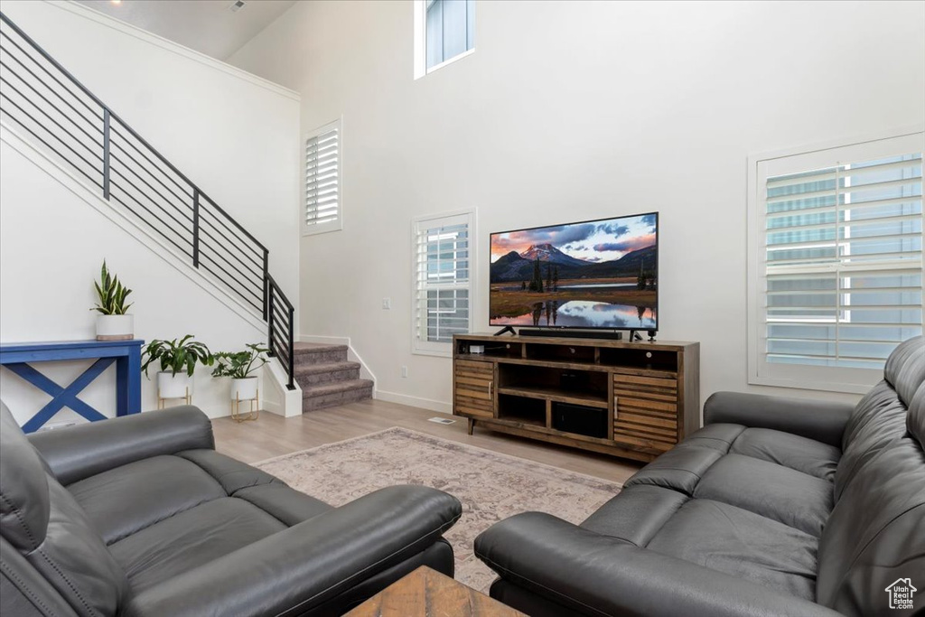 Living room with wood-type flooring and a high ceiling