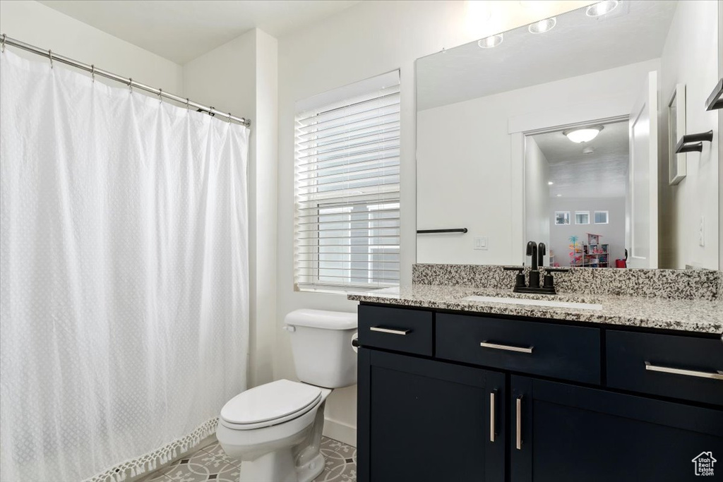 Bathroom with tile patterned floors, toilet, and vanity