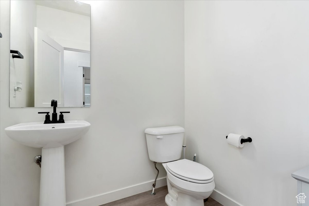 Bathroom featuring wood-type flooring and toilet