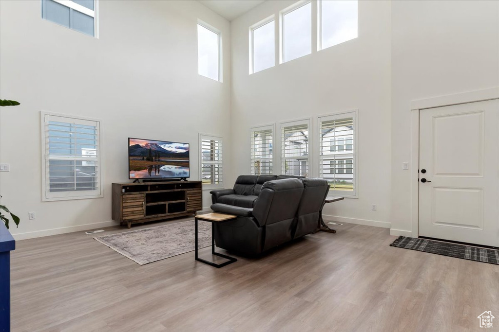 Living room featuring hardwood / wood-style flooring and a towering ceiling