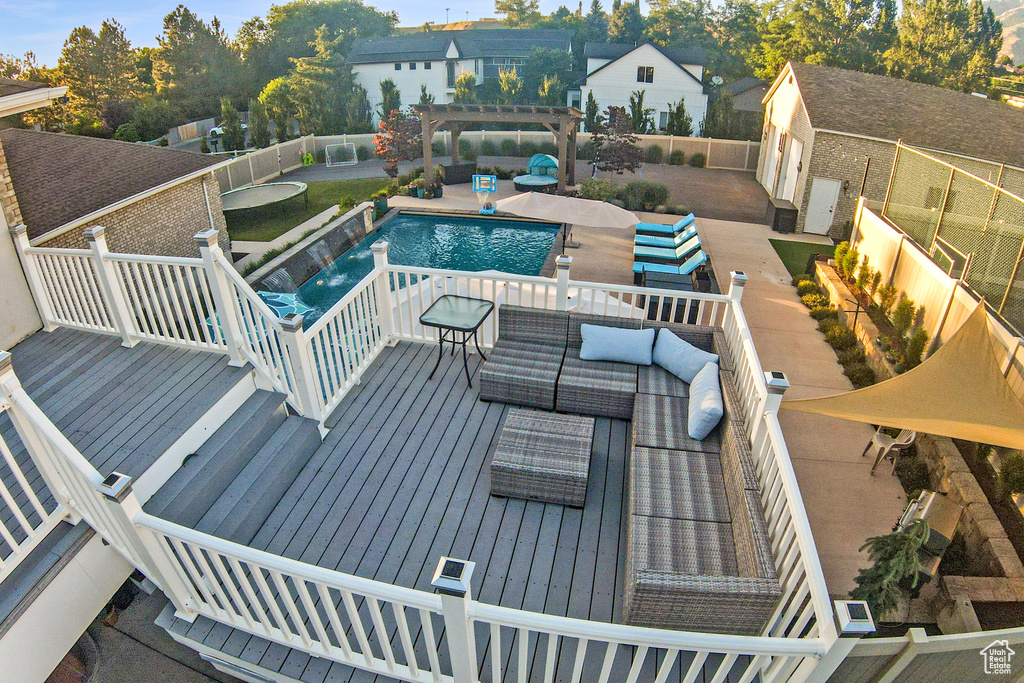 View of pool with an outdoor living space, an outbuilding, and a wooden deck