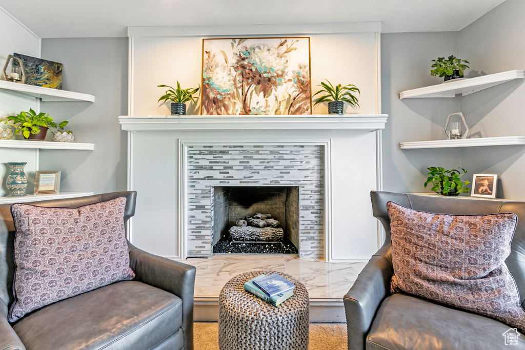 Living area with carpet and a tiled fireplace