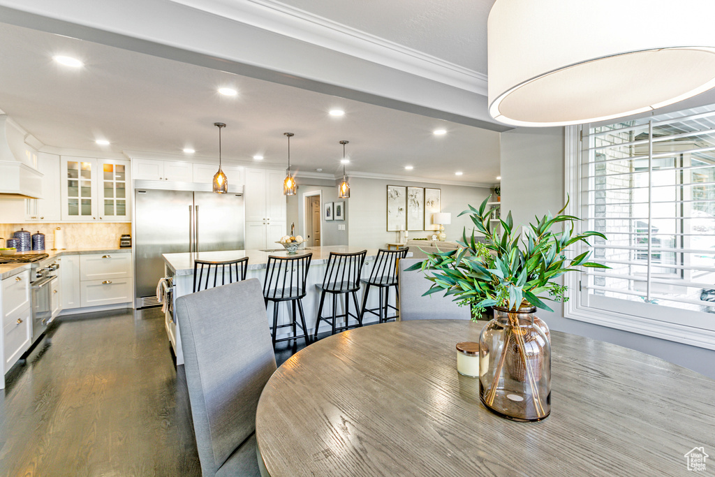 Dining space featuring ornamental molding and hardwood / wood-style floors