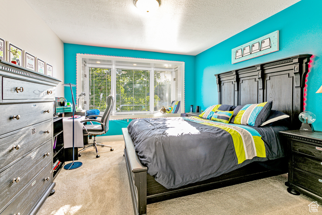 Bedroom with light carpet and a textured ceiling