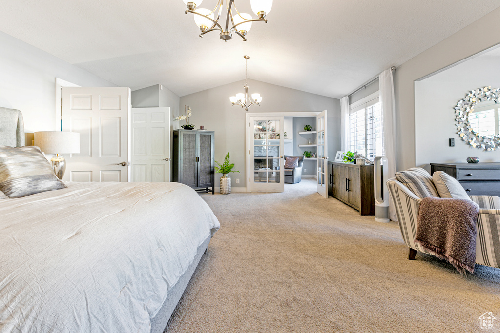 Carpeted bedroom featuring vaulted ceiling and an inviting chandelier