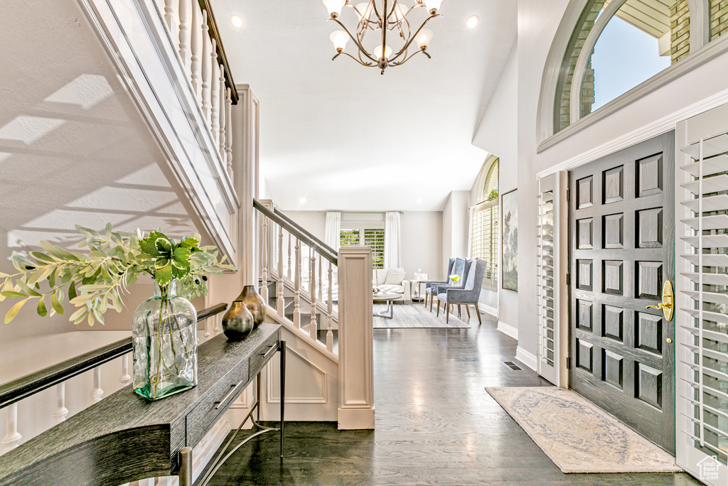 Entrance foyer featuring dark hardwood / wood-style floors and a chandelier