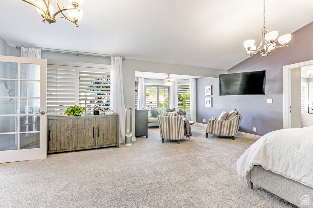 Carpeted bedroom with multiple windows, vaulted ceiling, and a chandelier