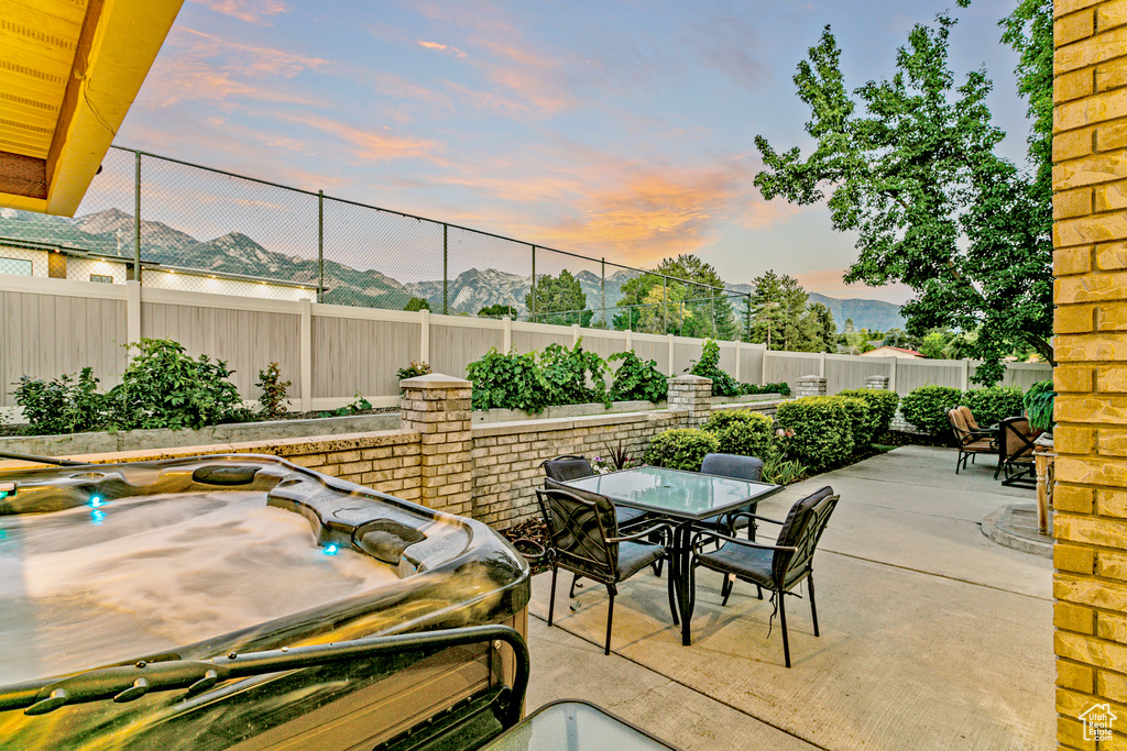 Patio terrace at dusk featuring a mountain view