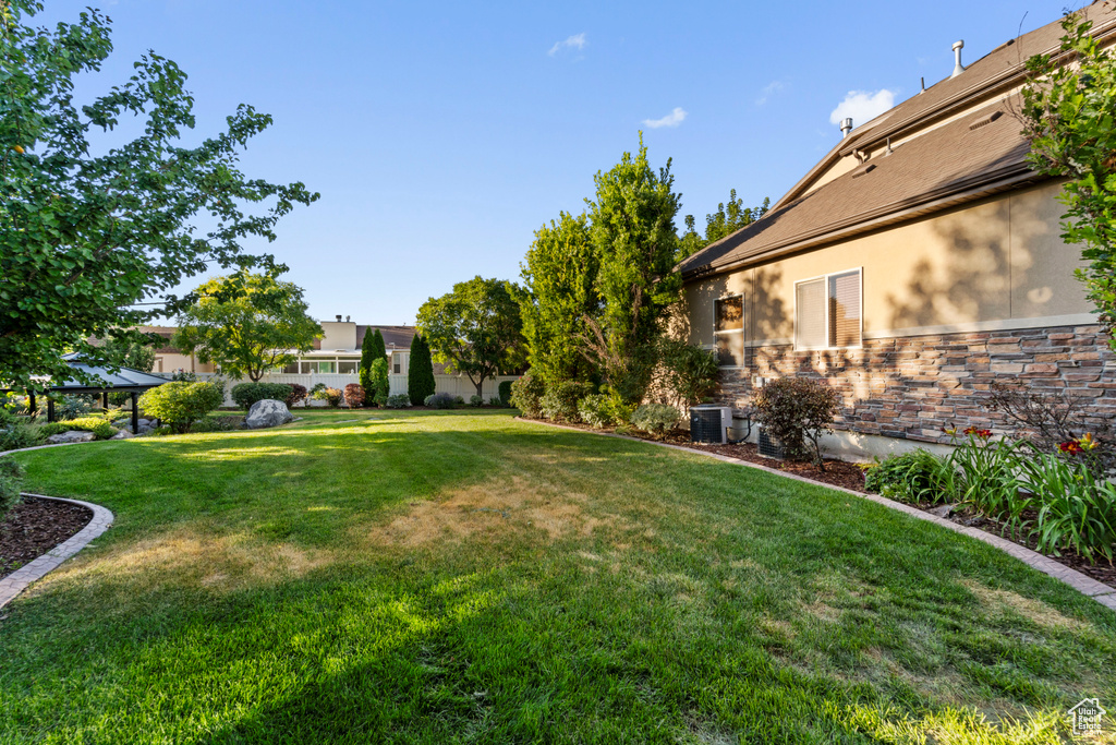 View of yard with central AC and a gazebo