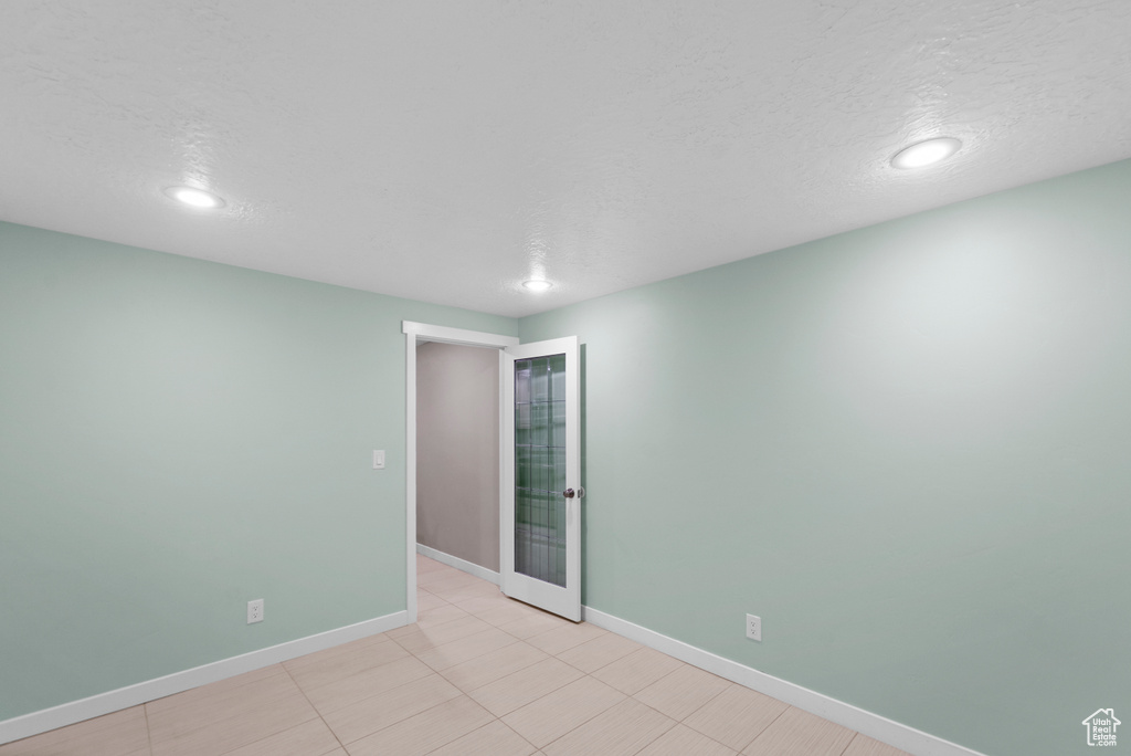 Spare room featuring light tile patterned floors and a textured ceiling