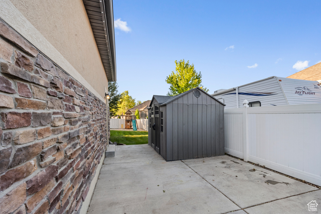 View of patio / terrace featuring a storage shed and a playground