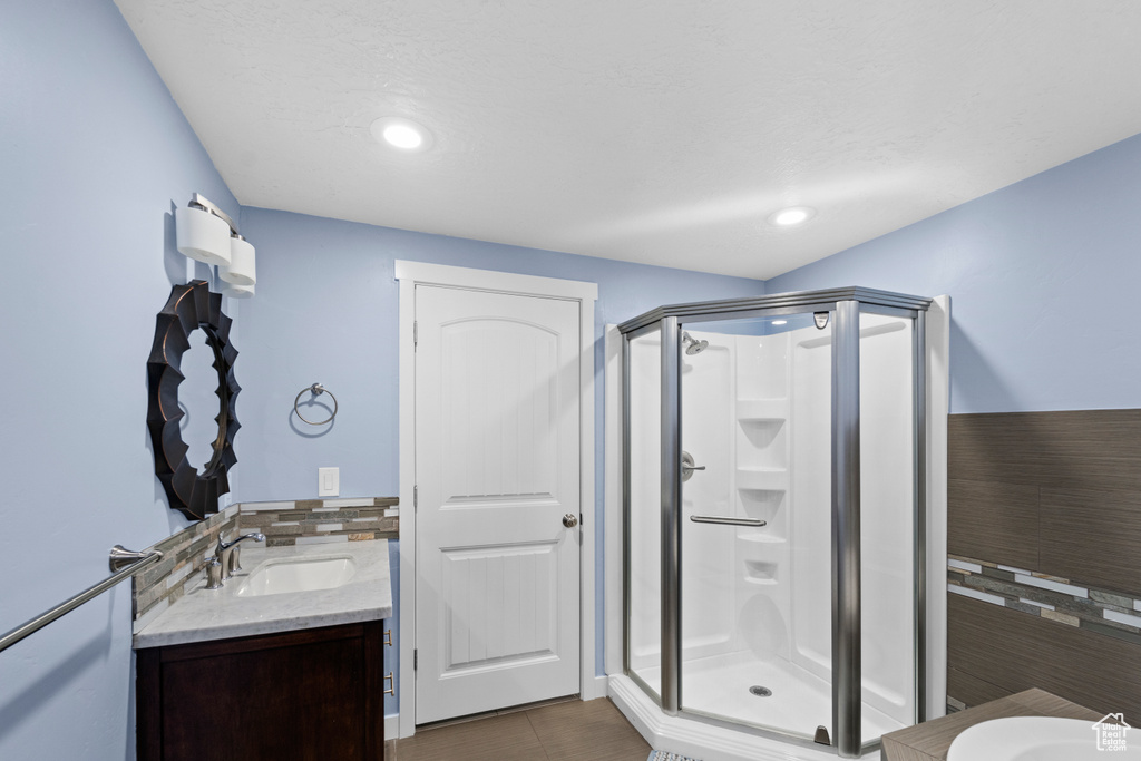 Bathroom featuring walk in shower, tile patterned floors, and vanity