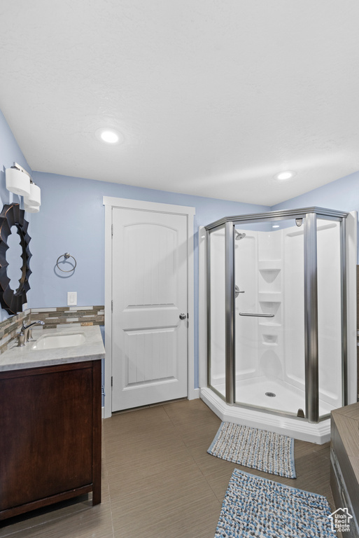 Bathroom featuring vanity, walk in shower, and tile patterned flooring