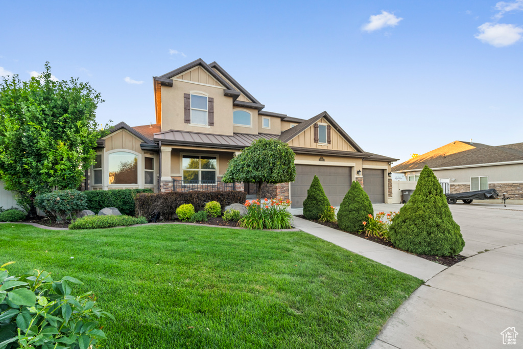 Craftsman house with a garage and a front lawn