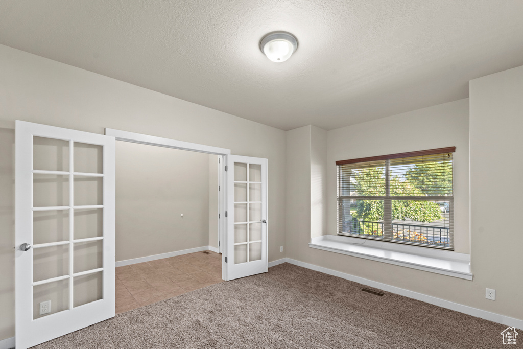 Interior space with light carpet and french doors